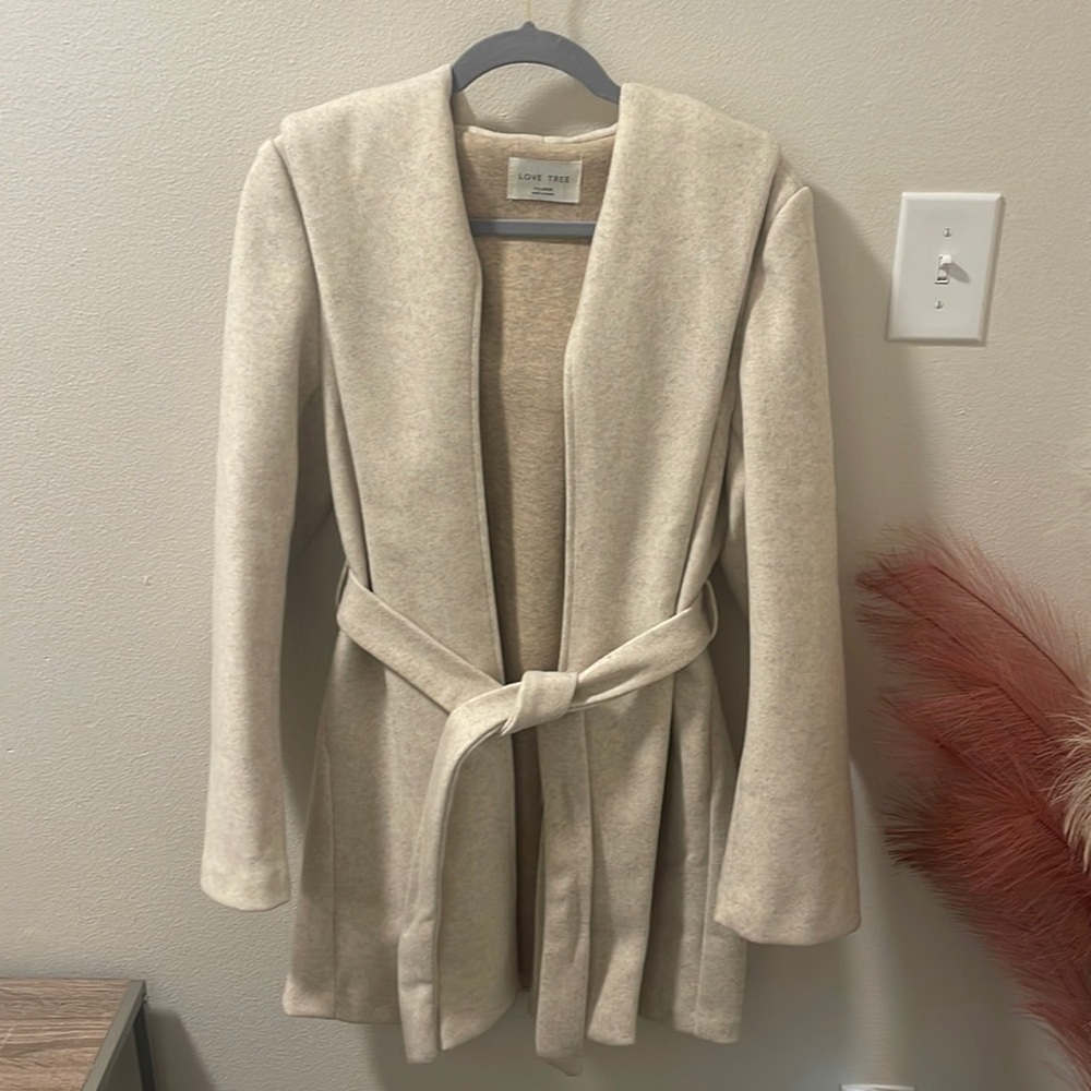 Tan felt material jacket with hood, waist tie and pockets.